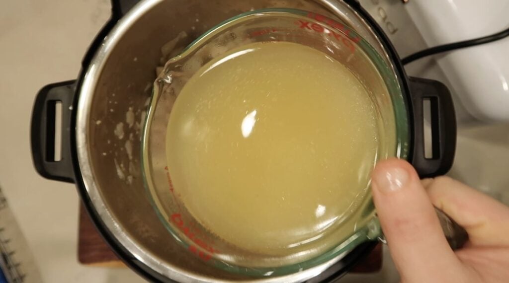 Adding broth to pot